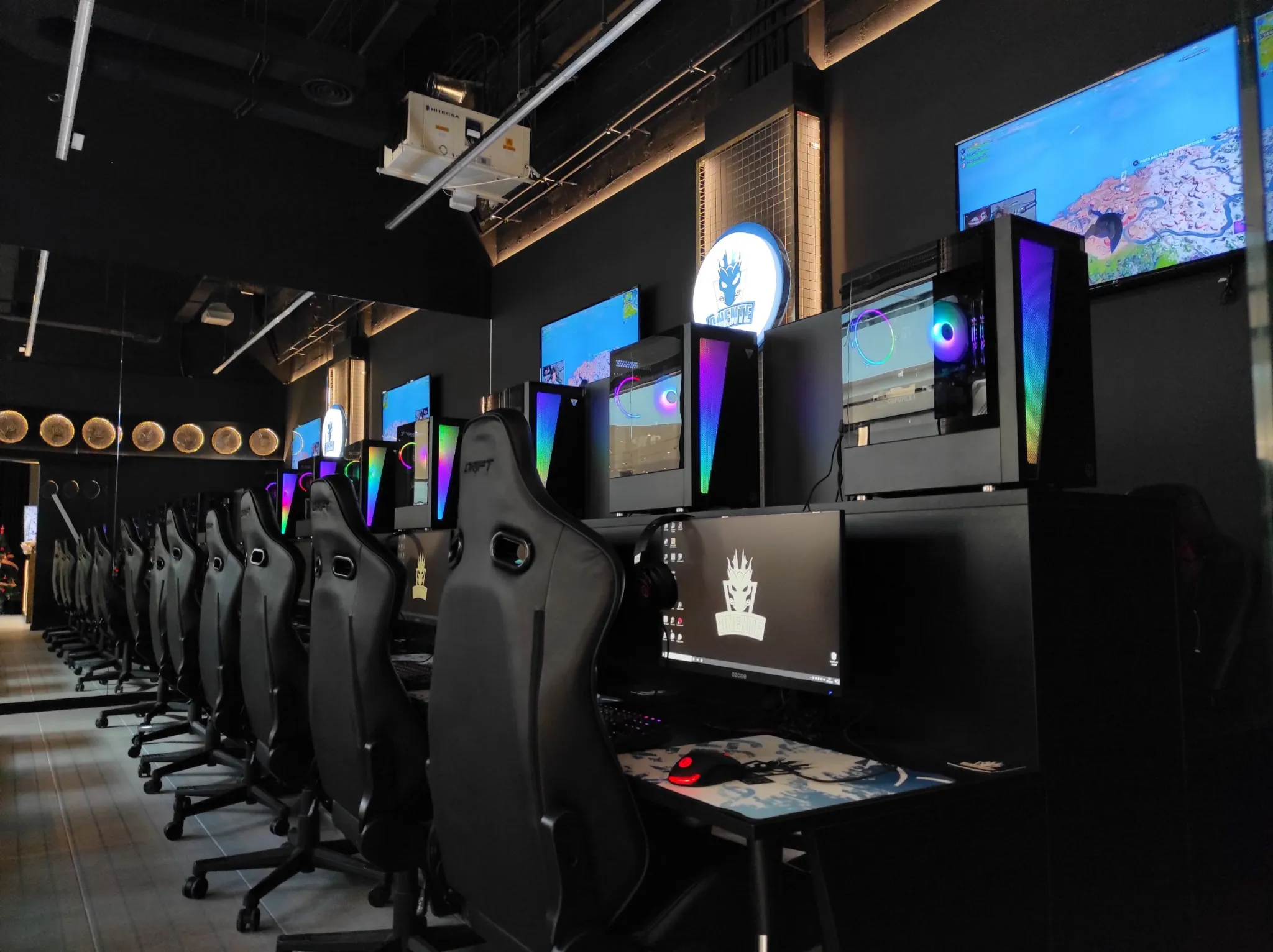 Puestos PC gaming del local, sillas y torres RGB en fila
